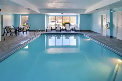 a large swimming pool with blue walls and tables and chairs at Hampton Inn Columbus-East in Pickerington