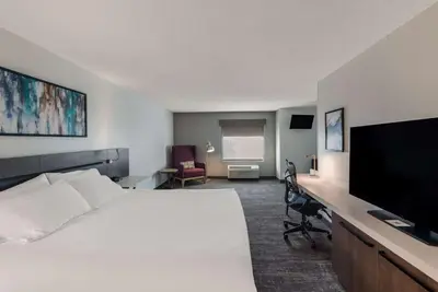 a hotel room with a bed and a desk with a television at Hilton Garden Inn Columbus/Grove City in Grove City