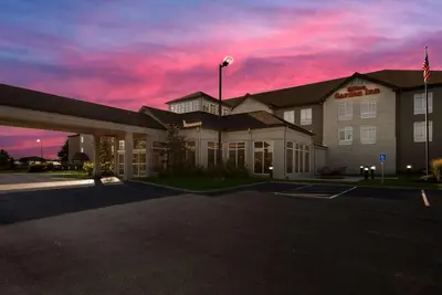 a hotel building with a sunset in the sky at Hilton Garden Inn Columbus/Grove City in Grove City