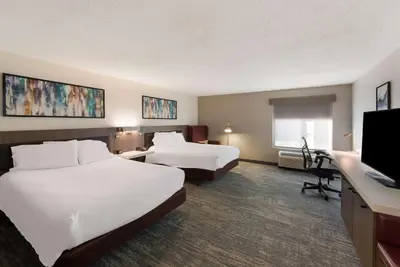 a hotel room with two beds and a flat screen tv at Hilton Garden Inn Columbus/Grove City in Grove City