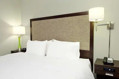 a hotel room with a white bed with two lamps at Hampton Inn & Suites Columbus Hilliard in Hilliard