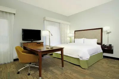 a hotel room with a bed and a desk with a television at Hampton Inn & Suites Columbus Hilliard in Hilliard