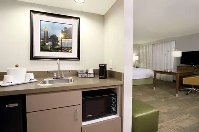a hotel room with a sink and a bedroom at Hampton Inn & Suites Columbus Hilliard in Hilliard