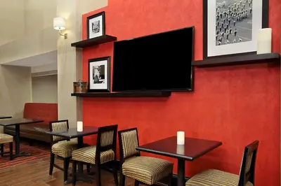 a restaurant with tables and a tv on a red wall at Hampton Inn & Suites Columbus Hilliard in Hilliard