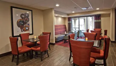 a restaurant with tables and chairs and a waiting room at Hampton Inn Columbus-South in Grove City
