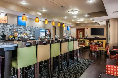 a bar in a restaurant with green chairs at Comfort Inn Blue Ash North in Blue Ash