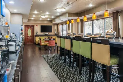 a bar in a restaurant with green chairs at Comfort Inn Blue Ash North in Blue Ash