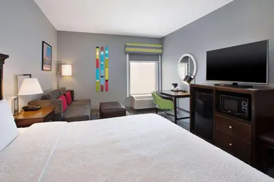 a hotel room with a bed and a flat screen tv at Hampton Inn Cincinnati Northwest Fairfield in Fairfield