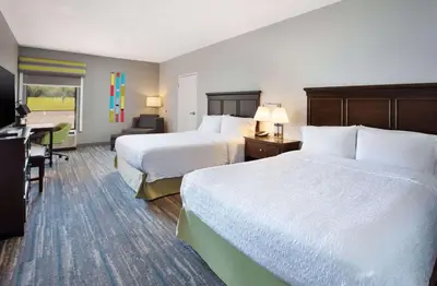 a hotel room with two beds and a desk at Hampton Inn Cincinnati Northwest Fairfield in Fairfield