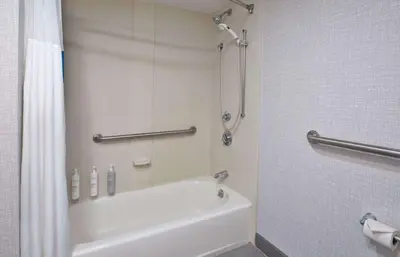 a bathroom with a shower and a white tub at Hampton Inn Cincinnati Northwest Fairfield in Fairfield