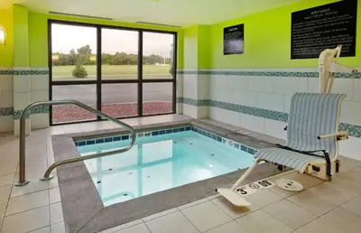 a swimming pool with a chair in a waiting room at Hampton Inn Cincinnati Northwest Fairfield in Fairfield