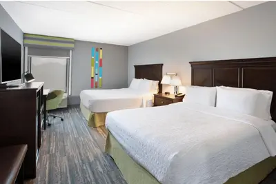 a hotel room with two beds and a television at Hampton Inn Cincinnati Northwest Fairfield in Fairfield