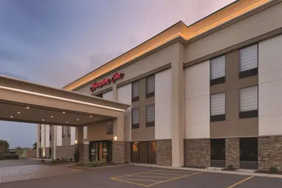 a hotel building with a red sign on it at Hampton Inn Cincinnati Kings Island in Mason