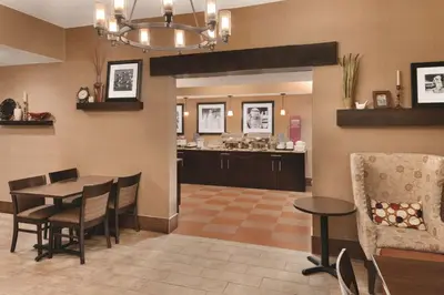 a dining room with a table and a kitchen at Hampton Inn Cincinnati Kings Island in Mason