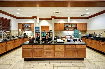 a large kitchen with wooden cabinets and a large island at Homewood Suites by Hilton Cincinnati-Milford in Milford