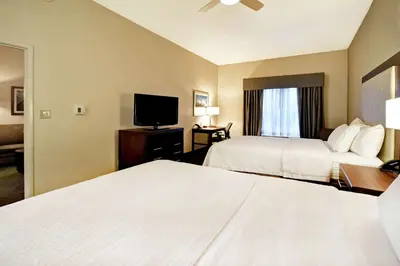 a hotel room with two beds and a flat screen tv at Homewood Suites by Hilton Cincinnati-Milford in Milford