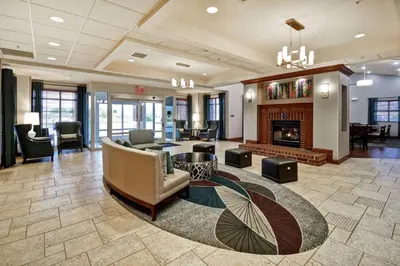 a lobby with a fireplace and a couch and chairs at Homewood Suites by Hilton Cincinnati-Milford in Milford