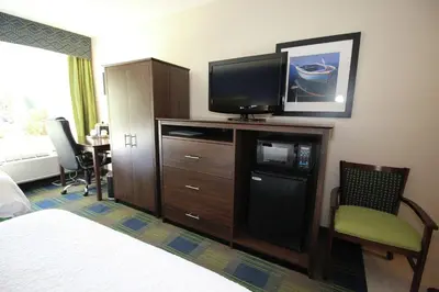 a hotel room with a bed and a flat screen tv at Hampton Inn Sandusky-Central in Sandusky