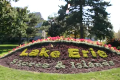 a sign in the grass with flowers in a park at Hampton Inn Sandusky-Central in Sandusky