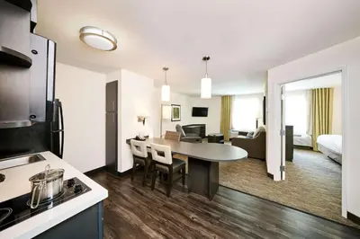 a kitchen and living room with a table in a room at Sonesta Simply Suites Pittsburgh Airport in Imperial