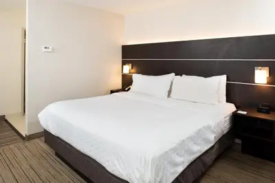 a large bed in a hotel room with white sheets and pillows at Holiday Inn Express Cincinnati West by IHG in Dent