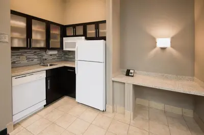 a kitchen with a white refrigerator and a counter at Staybridge Suites Columbus-Airport by IHG in Columbus