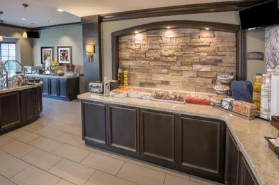 a food counter in a restaurant with a brick wall at Staybridge Suites Columbus-Airport by IHG in Columbus