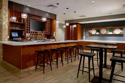 a bar with a bunch of stools in a room at SpringHill Suites by Marriott Dayton Beavercreek in New Germany