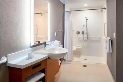a white bathroom with a sink and a shower at SpringHill Suites by Marriott Dayton Beavercreek in New Germany