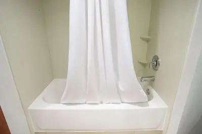 a white shower with a white shower curtain in a bathroom at The Hotel at Dayton South in Dayton