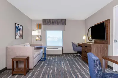 a living room with a couch and a desk at Hampton Inn & Suites Muncie in Muncie