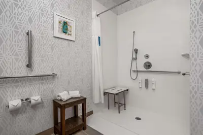 a white bathroom with a shower and a sink at Hampton Inn & Suites Muncie in Muncie