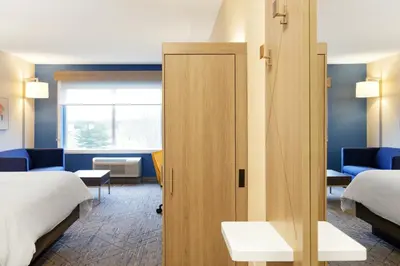 a room with two beds and a sliding door at Holiday Inn Express Hotel & Suites Cincinnati-Blue Ash by IHG in Blue Ash
