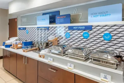 a counter with a bunch of trays of food at Holiday Inn Express Hotel & Suites Cincinnati-Blue Ash by IHG in Blue Ash