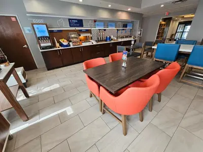 a restaurant with a table and chairs and a counter at Holiday Inn Express Hotel & Suites Cincinnati-Blue Ash by IHG in Blue Ash