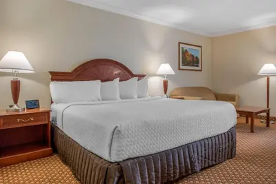 a hotel room with a large bed with two lamps at Quality Hotel Conference Center Cincinnati Blue Ash in Blue Ash