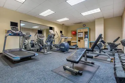 a gym with several treadmills and cardio machines at Quality Hotel Conference Center Cincinnati Blue Ash in Blue Ash