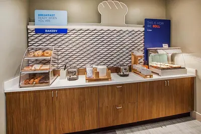 a bakery with a counter with donuts on it at Holiday Inn Express Hotel & Suites Fort Wayne by IHG in Fort Wayne