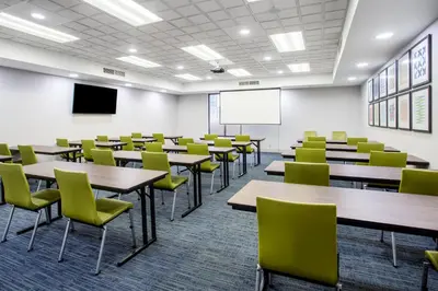 an empty lecture room with tables and chairs at Holiday Inn Express Hotel & Suites Fort Wayne by IHG in Fort Wayne