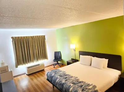 a bedroom with a bed and a green wall at Willow Lodge Willoughby Cleveland in Willoughby