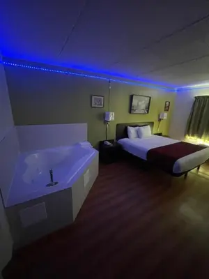 a bedroom with a bed and a bathtub and a bed and a sink at Willow Lodge Willoughby Cleveland in Willoughby