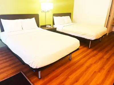 two beds in a room with wooden floors at Willow Lodge Willoughby Cleveland in Willoughby