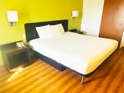 a large bed in a room with a wooden floor at Willow Lodge Willoughby Cleveland in Willoughby