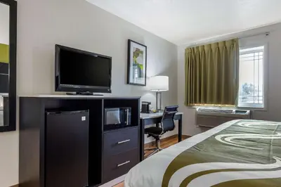 a hotel room with a bed and a flat screen tv at Quality Inn Coraopolis in Coraopolis