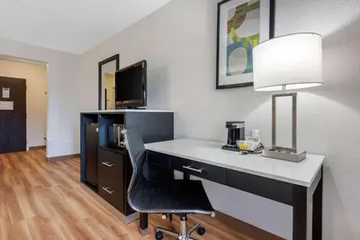 a desk with a lamp and a chair in a room at Quality Inn Coraopolis in Coraopolis
