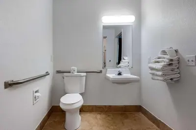 a bathroom with a toilet and a sink and a mirror at Quality Inn Coraopolis in Coraopolis