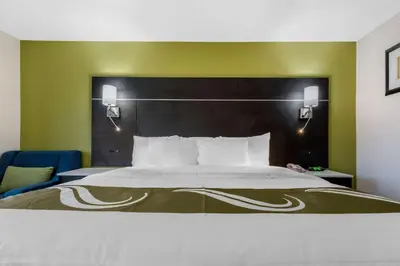 a bedroom with a large bed with a black headboard at Quality Inn Coraopolis in Coraopolis