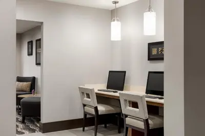 an office with a desk with two computers and chairs at Staybridge Suites Fort Wayne by IHG in Fort Wayne