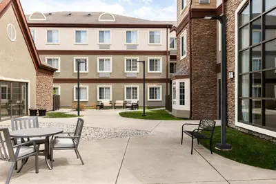 a patio with a table and chairs in front of a building at Staybridge Suites Fort Wayne by IHG in Fort Wayne