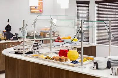 a breakfast buffet with food and drinks on a counter at Staybridge Suites Fort Wayne by IHG in Fort Wayne